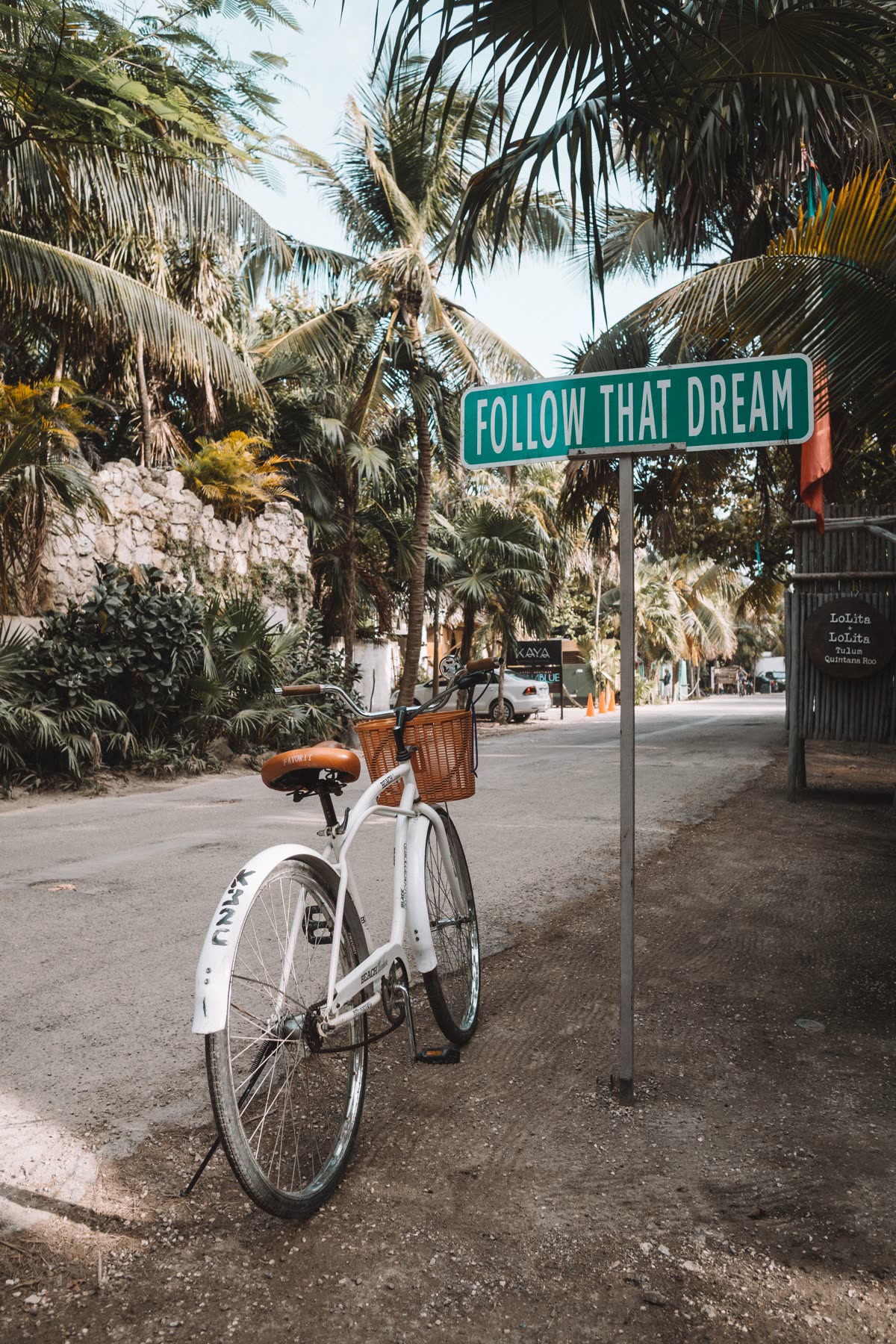 A bicycle beside the Follow That Dream sign in Tulum