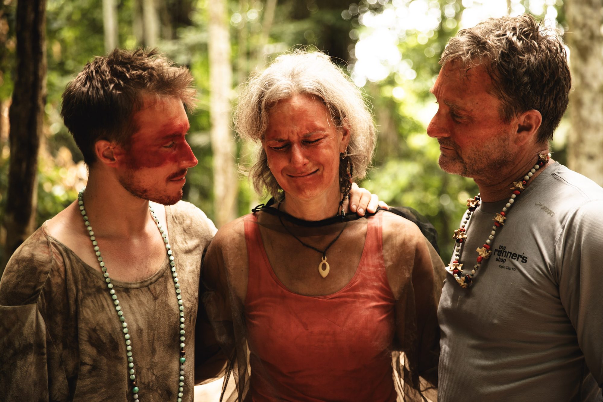 Three people holding each other in the forest in Acre, Brazil